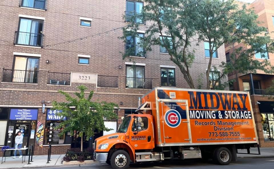 An orange shredding services truck parked outside of the 44th Ward Office on Sheffield Avenue in Chicago.